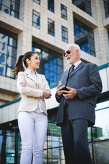 Wall Mural - An older man and a young colleague are talking about work