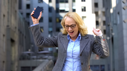 Delighted office director dancing outdoors, work achievement, celebration career