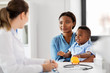 © Syda Productions - medicine, healthcare and pediatry concept - happy african american mother with baby son and caucasian doctor at clinic