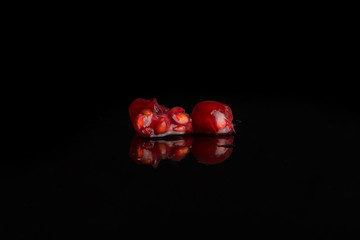 Group of two pieces of fresh red currant isolated on black glass