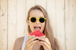 © PhotoGranary - Summertime in garden. Young beautiful and smiling woman in garden with juicy watermelon.