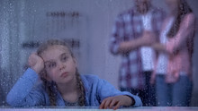 Unhappy Little Girl Behind Rainy Window, Foster Parents Coming To Adopt Child