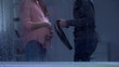 Man threatening pregnant woman with belt behind rainy window, family assault