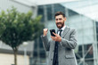 © Petryshak - Dance success. Successful confident businessman celebrates his success. Young man formal wear his hands up and rejoice.
