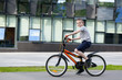 © somemeans - Schoolboy rides a bicycle. Summer holidays. Urban background