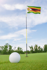 Wall Mural - Zimbabwe flag on golf course putting green with a ball near the hole