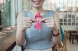 © SewcreamStudio - Asian woman holding pink ribbon, breast cancer awareness, October pink concept