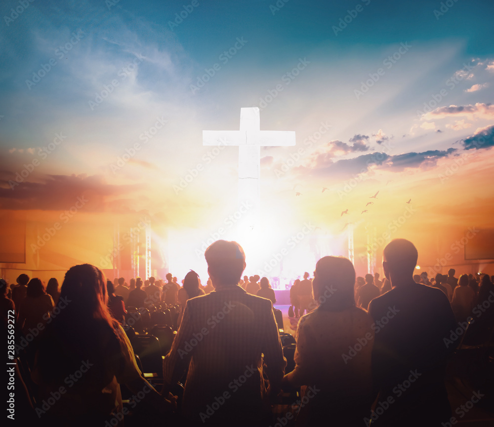 Worship concept: Group of people holding hands praying worship at sunset background - obrazy, fototapety, plakaty 