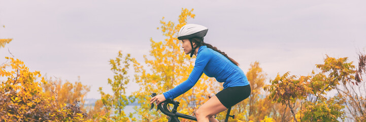 Wall Mural - Autumn sport active lifestyle cyclist woman doing bicycle in fall nature forest background . Panoramic header landscape.