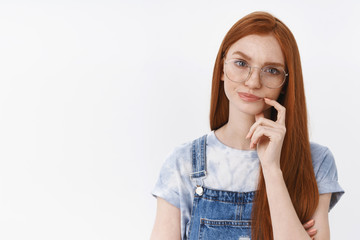 Wall Mural - Serious-looking suspicious perplexed redhead smart girl wear glasses frowning, smirking unsatisfied and doubtful touch lip, thinking hesitating making choice, stand white background puzzled