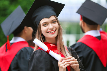 Sticker - Female student in bachelor robe and with diploma outdoors