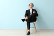 © Pixel-Shot - Fashionable senior man sitting on chair near color wall