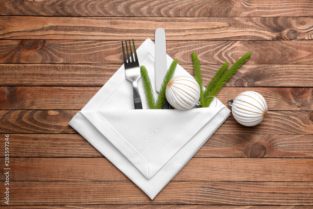 Cutlery and napkin for Christmas table setting on wooden background