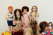 Antique Porcelain Doll In Vintage Dresses In A Blurred Light