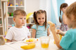 © Oksana Kuzmina - Kids have a lunch in daycare centre. Children eating fresh fruits in kindergarten