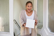 © MrsLePew - woman receiving package box from postman in front of house
