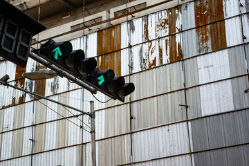 Traffic light near metal sheet wall of construction site