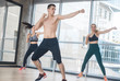 © KONSTANTIN SHISHKIN - Fitness training in the studio - two young women training with their coach