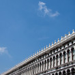 Building facade under clear blue sky with light white clouds in Piazza San Marco. St. Mark Square, Venice Italy