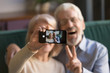 © fizkes - Happy old couple taking selfie on cellphone, focus on display