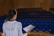 Businesswoman Practicing And Learning Script While Standing In The Auditorium