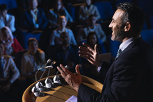 Businessman Standing And Giving Presentation In The Auditorium 