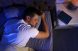 © New Africa - Handsome man sleeping on pillow in dark room at night, view from above. Bedtime