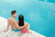 © New Africa - Woman in bikini with boyfriend near outdoor pool. Happy young couple