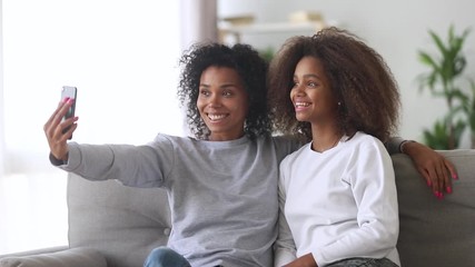 Wall Mural - Young mother and grown up daughter adolescent take self portrait