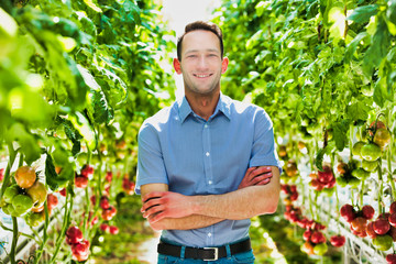 Portrait of confident supervisor standing in greenhouse