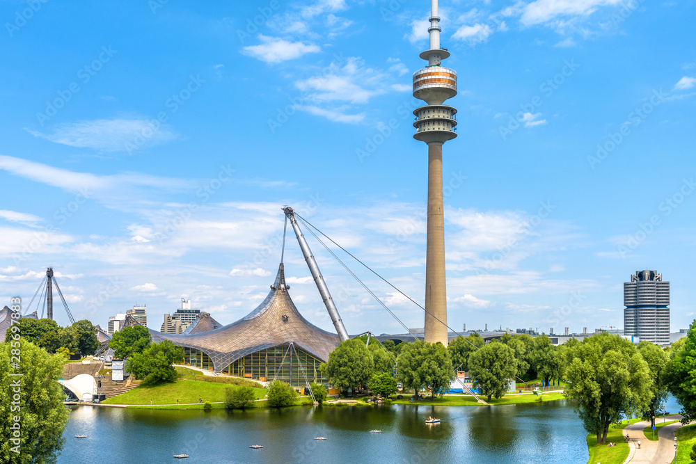 Olympic Park or Olympiapark in Munich. Landscape of former sport district. Scenery of Munich with tower and lake. - obrazy, fototapety, plakaty 