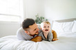 © Louis-Photo - A Father with cute baby son on bed at home