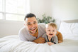 © Louis-Paul Photo - A Father with cute baby son on bed at home