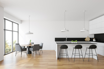 White kitchen interior with bar and table