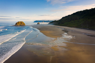 Wall Mural - Sunrise View of Cannon Beach, Oregon. Beautiful morning light illuminates the white sand beaches and the Pacific Ocean along the stunning Oregon coastline during the summer season. 