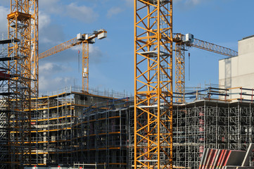 large construction site with scaffolded buildings and cranes