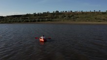 Aerial View Of Person Chilling In Small Red Rowing Boat At Sunset Drone Footage