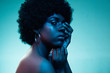 Deep ocean. Portrait of female fashion model in neon light on blue gradient studio background. Beautiful african woman with trendy make-up and well-kept skin. Vivid style, beauty, cosmetics concept.