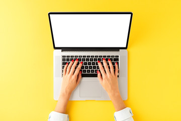 Woman’s hand working on laptop with empty screen. Office desktop concept. Top view