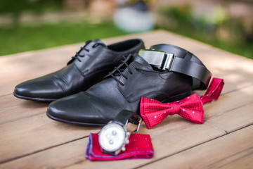 Groom's accessoriers for a wedding - shoes, cloth, bow tie, watch and a leather belt . 