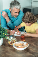 Wall Mural - Father and son making school homework at home