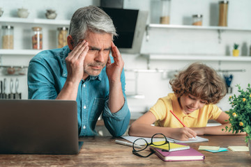 Wall Mural - Father helping with school homework his little son