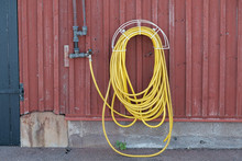Yellow Water-hose On Red Wall - Landscape