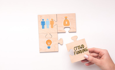 Wall Mural - Puzzle of four pieces showing crowdfunding concept on white