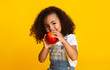 © Prostock-studio - Yummy. Little afro girl eating red apple