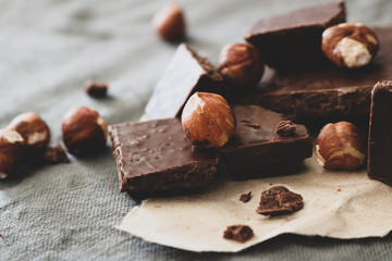 Dark chocolate and hazelnuts on a grey background.