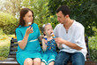 © jonnyslav - Father, mother and daughter sit on bench and eat ice cream. A man shares his ice cream with a girl. Woman pregnant.