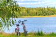 © Andrey Nikitin - Two bicycles stand on the river bank.