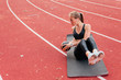 © splitov27 - Young fit woman perfoms her body while doing exercise with medicine ball on mat at stadium track with red coating. Healthy lifestyle