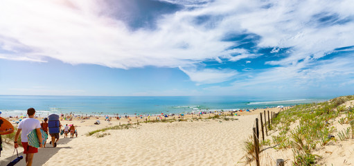 summer beach with crowd of surfers in france